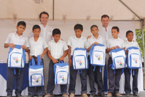 Acisclo Valladares, Director de Fundación Tigo y Luis Valladares, CEO de Tigo, entregando mochilas y útiles escolares a los estudiantes. 
