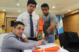Este es uno de los prototipos de mano biónica en los que trabajan Alí Lemus (primero a la izquierda) y su grupo.